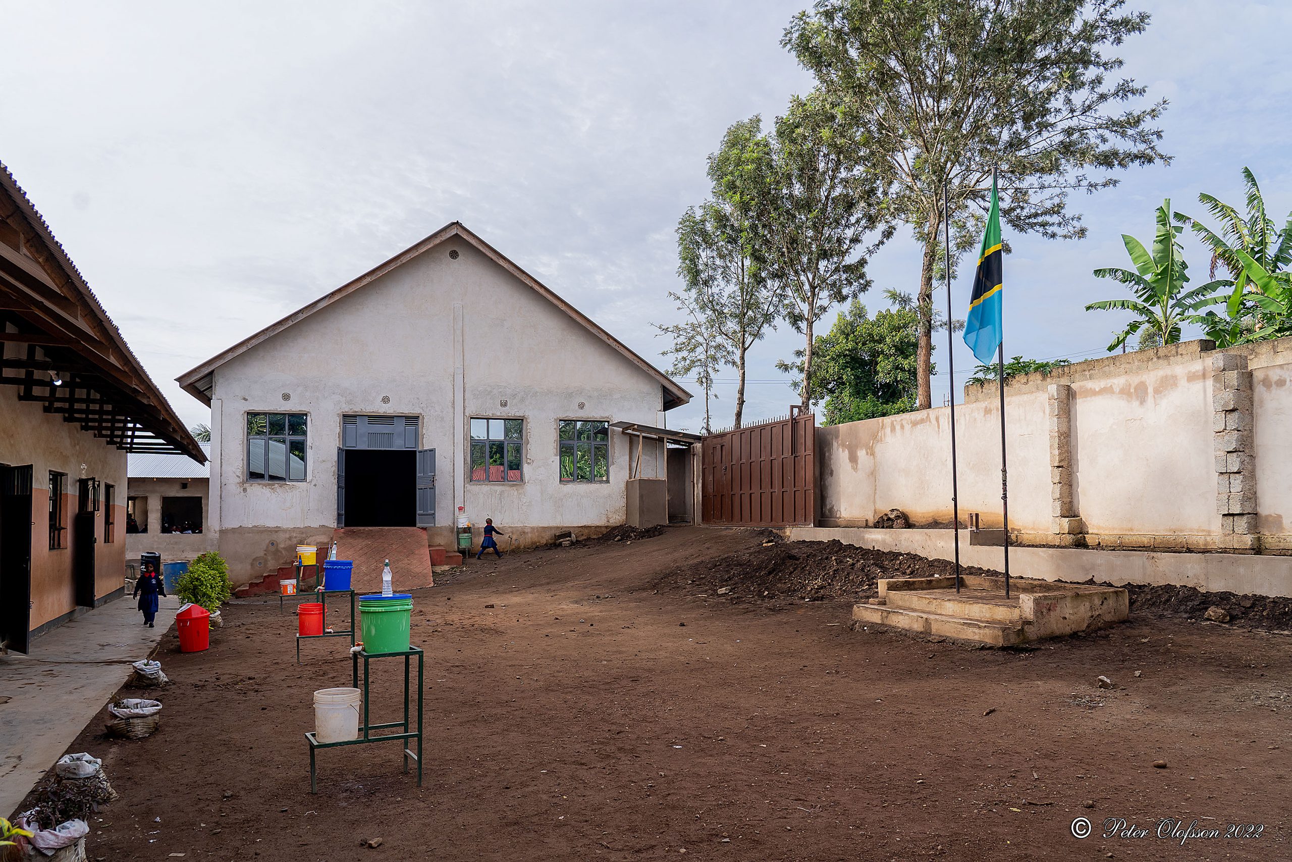 Skolgården med nya muren/grinden och Tanzanias flagga.